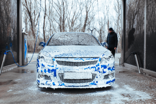 man-with-gun-apply-foam-car-self-service-car-wash 1