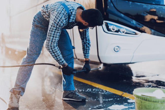 young-man-washing-bus-using-high-pressure-water-selective-focus